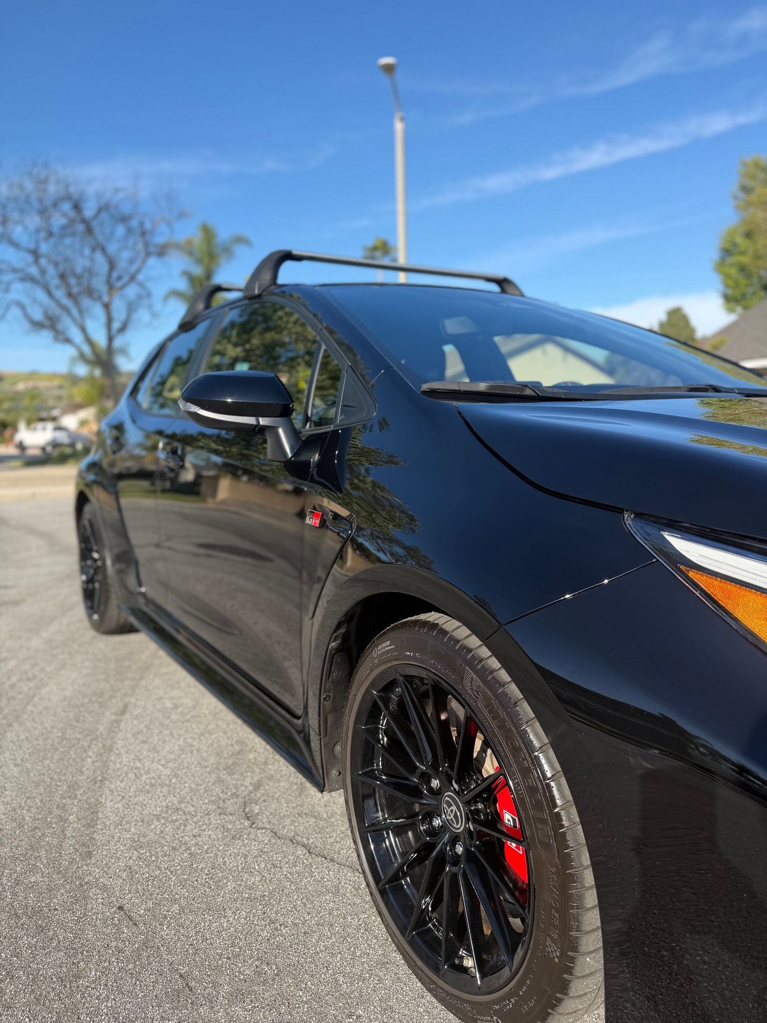 Front of a black Toyota GR Corolla with glossy paint and gloss black wheels